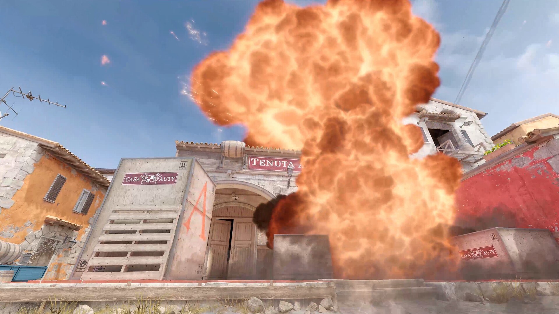 Counter-Strike 2 explosion erupting in front of stone buildings on an Italian map
