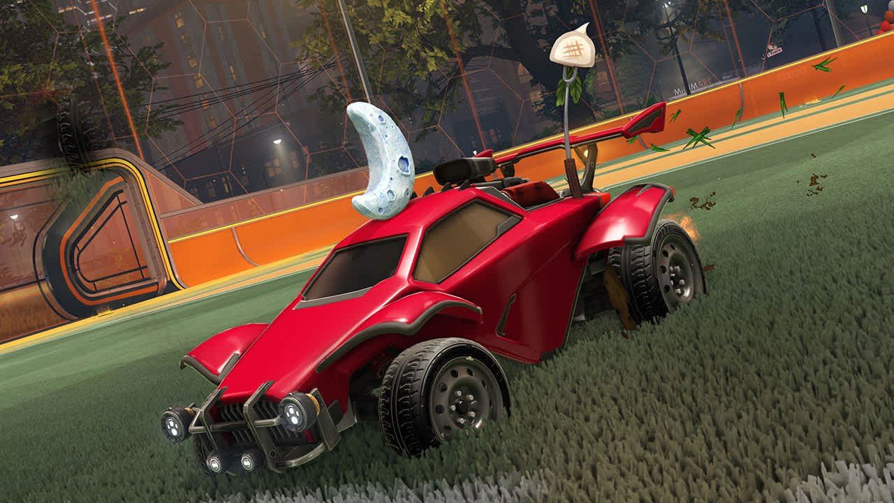 Red Rocket League car with a crescent moon topper on the pitch