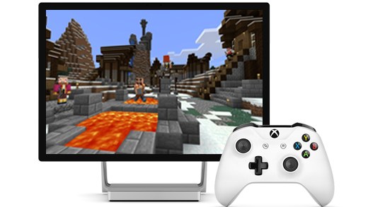White Xbox Wireless Controller beside a Surface Studio showing Minecraft