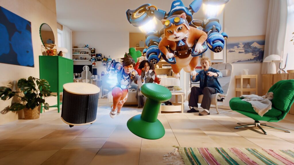A living room furnished with the IKEA YXSTABY gaming collection, including the green thumb stick stool and rolling side table